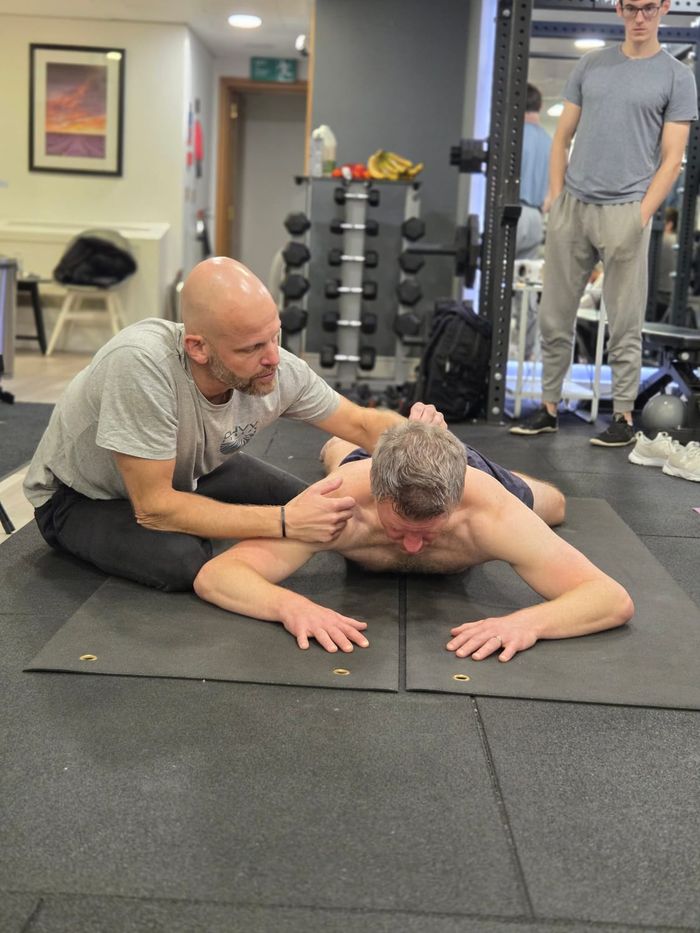 Ruud Alsemgeest guiding an attendee through a supine developmental position during DNS Exercise Part I
