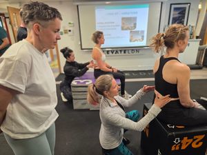 Veronika Cmolikova cueing a long-sit position with an attendee during DNS Exercise Part I at Elevate LDN
