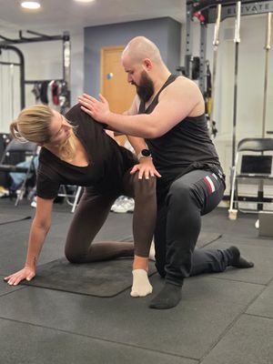 Łukasz Burliński assisting a supine hip position during DNS Exercise Part II