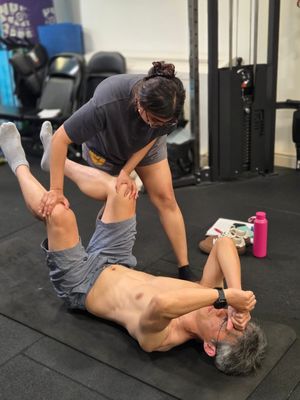 Instructor assessing an attendee's hip in supine during DNS Exercise Part III at Elevate LDN