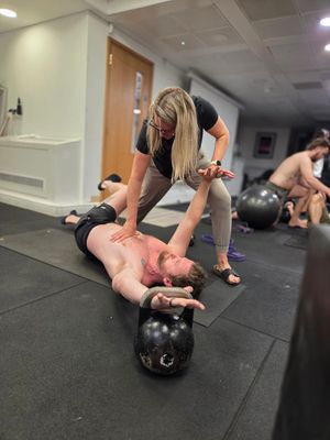 Instructor coaching a kettlebell-loaded position during DNS Exercise Part III at Elevate LDN